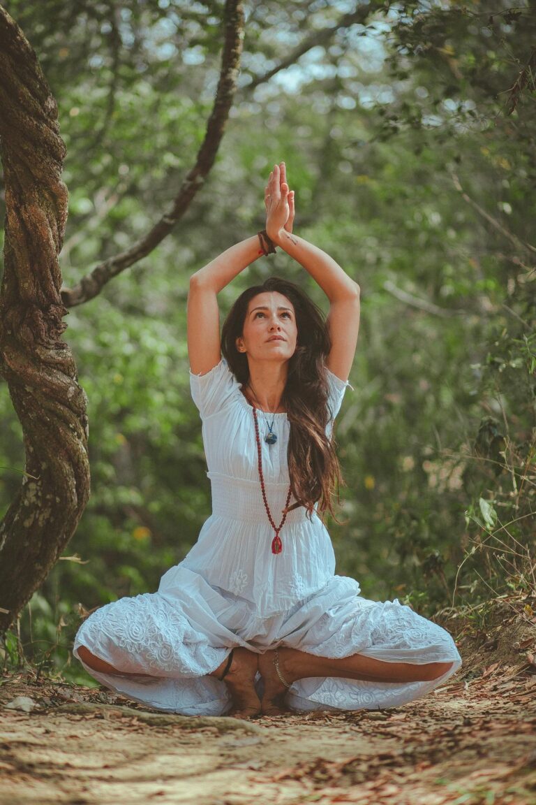 Woman meditating in a peaceful forest setting, embracing calmness and balance.