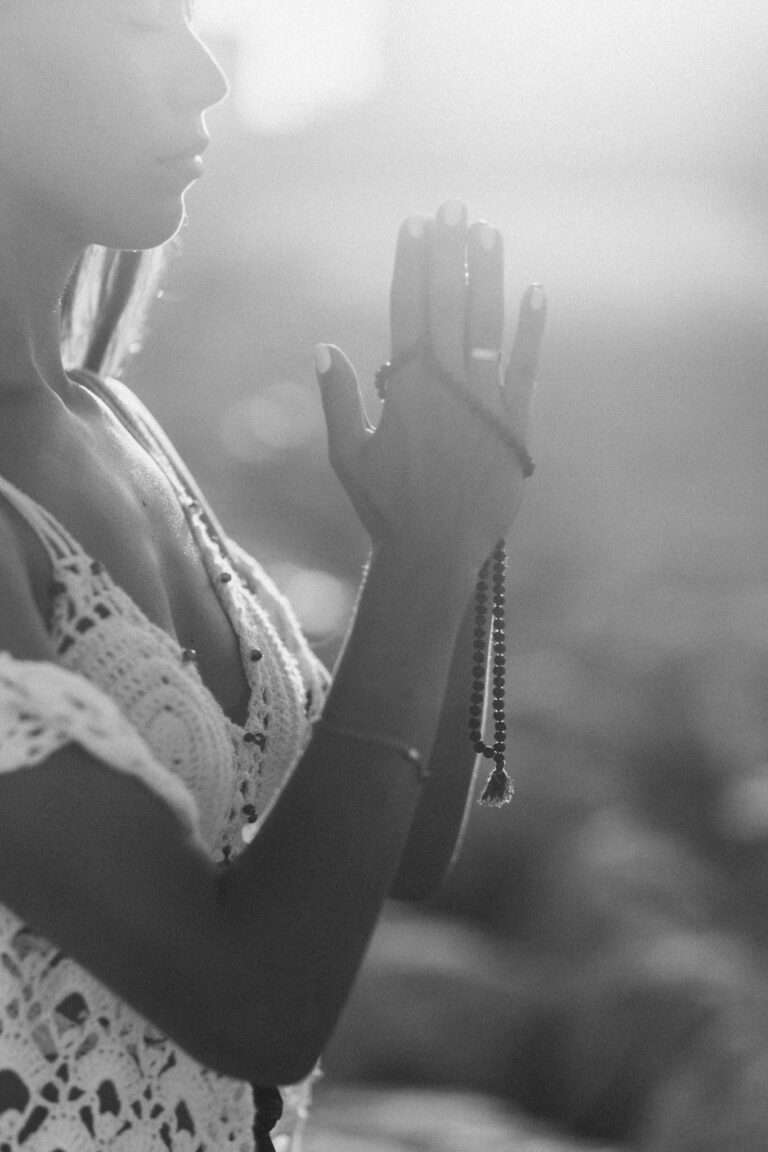 Woman practicing meditation outdoors in calm daylight with a boho vibe.